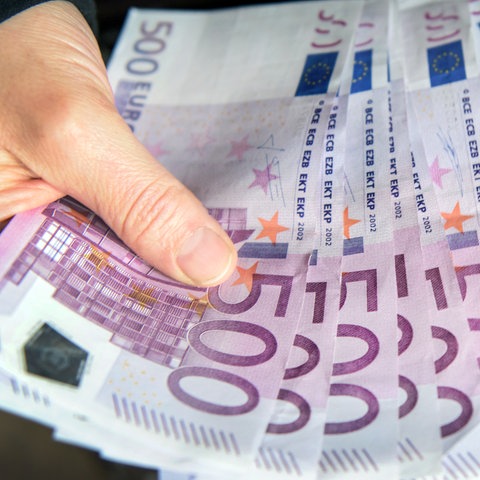Zwei Hände fächern acht 500-Euro-Scheine auf