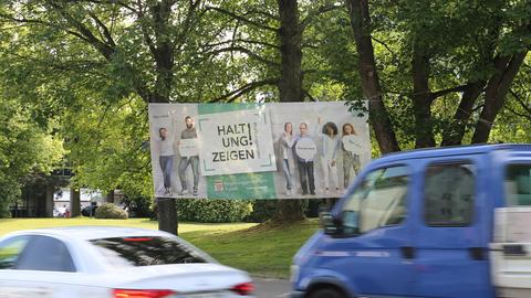 Großformatiges Plakat an einer mit Autos befahrenen Straße mit dem Slogan "Haltung zeigen".