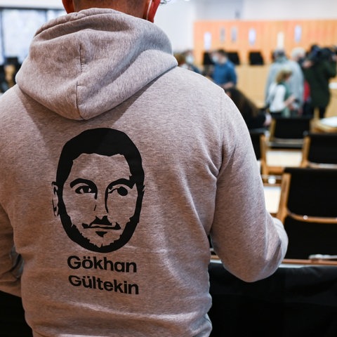 Zuhörer im hessischen Landtag, der einen Pullover mit der Abbildung eines der Opfer des rassistischen Attentats von Hanau, Gökhan Gültekin, trägt
