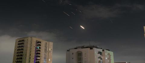 Flammen von Explosionen am Himmel über Israels Hauptstadt Tel Aviv, während Israels Raketenabwehrsystem Raketen und Drohnen aus dem Iran abfängt. 