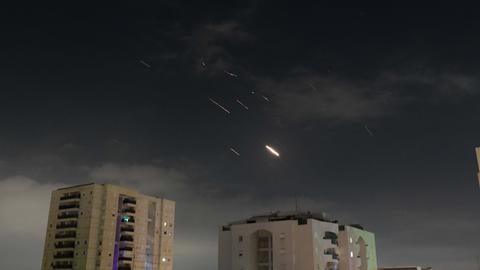 Flammen von Explosionen am Himmel über Israels Hauptstadt Tel Aviv, während Israels Raketenabwehrsystem Raketen und Drohnen aus dem Iran abfängt. 