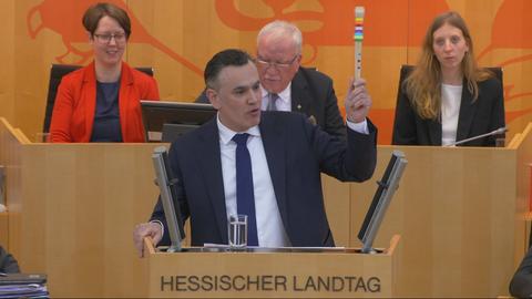 FDP-Fraktionschef Stefan Naas hält im Landtag eine Blockflöte hoch.
