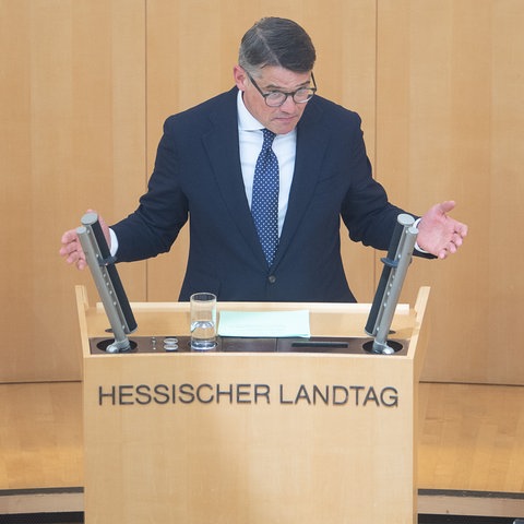 Ministerpräsident Boris Rhein steht im Landtag am Redepult und spricht.