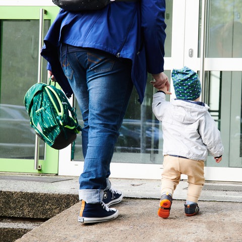 Mutter mit Kind vor der Kita