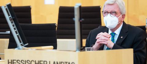 Volker Bouffier am Dienstag im Landtag sitzend. Seine Hände sind wie zu einem Gebet gefaltet und sein Blick geht nach oben Richtung Decke.