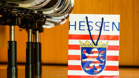 Tüte mit Hessen-Logo in einer Sitzreihe ds Landtags