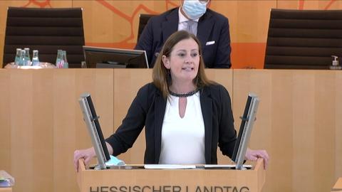 Janine Wissler steht am Rednerpult im hessischen Landtag und spricht.