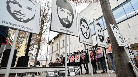 Menschen halten Schilder mit den Köpfen und Namen der Opfer von Hanau hoch. Im Vordergrund ein Schild mit dem Schriftzug "Aufklärung".