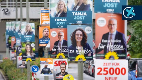 An einer Straße hängen mehr als ein Dutzend Wahlplakate verschiedener Parteien. 