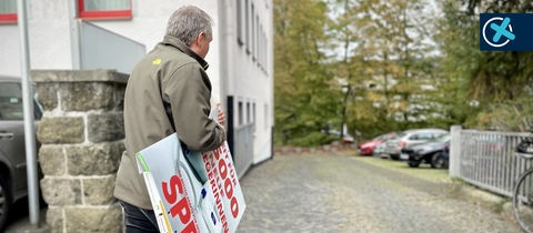 SPD-Chef Manfred Merz hängt die Wahlplakate der SPD ab.