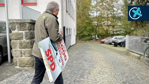 SPD-Chef Manfred Merz hängt die Wahlplakate der SPD ab.