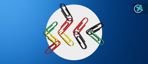 Büroklammern in den Farben schwarz, rot, grün und gelb liegen immer wieder neu verknüpft nebeneinander auf einem hellgrauen Kreis. Der Kreis ist vor einen blauen Hintergrund mit Verlauf gesetzt. Darauf ein Wahlkreuz rechts oben. 