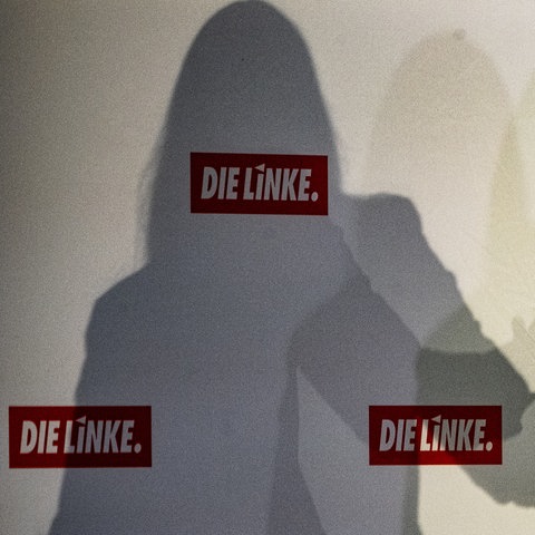 Der Schatten von Linken-Bundeschefin Janine Wissler mit Partei-Logos