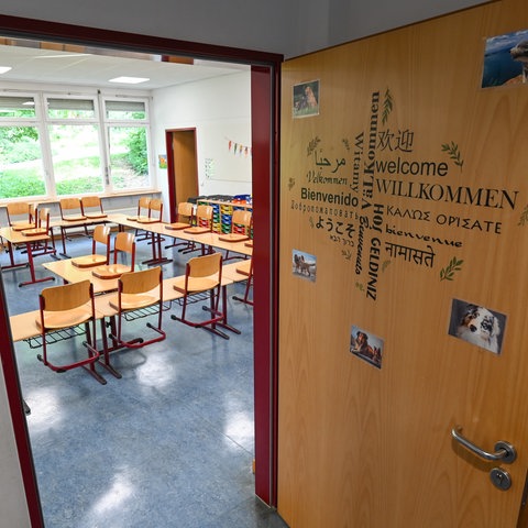 Das Wort "Willkommen" in mehreren Sprachen an der Tür eines Klassenzimmers.