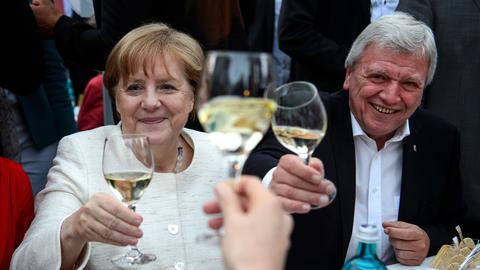 Angela Merkel und Volker Bouffier, beide mit einem Weißweinglas in der Hand