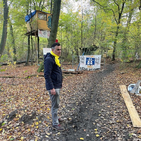 FDP-Politiker Stefan Naas im Fechenheimer Wald vor einem Baumhaus von Waldbesetzern, die einen Autobahnausbau verhindern wollen