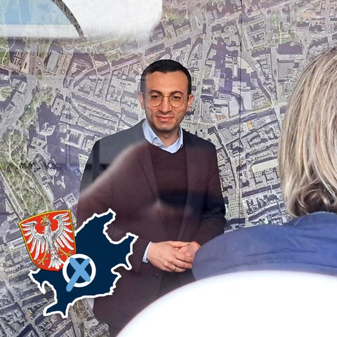 Mike Josef während einer Pressekonferenz vor einer wandgroßen Frankfurt-Karte stehend