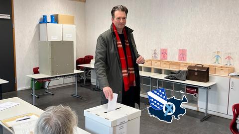 Sven Schoeller steckt im Wahllokal einen Stimmzettel in die Wahlurne.