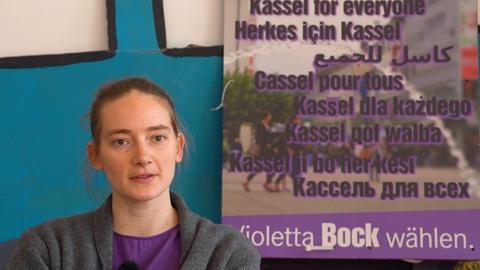 Violetta Bock, Kandidatin bei der OB-Wahl Kassel, vor einem Wahlplakat