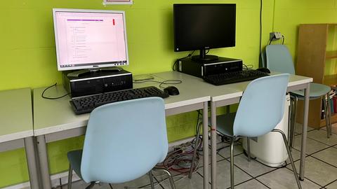 Zwei Computer stehen auf einem Schreibtisch. 