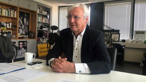 Der Grünen-Oberbürgermeister Jochen Partsch sitzt in seinem Büro an einem Tisch.