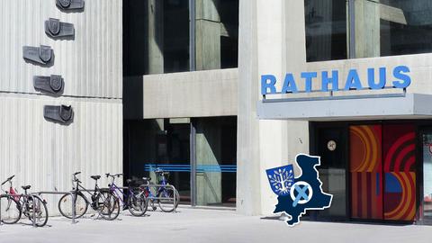 Zeitgenössisches Gebäude aus Beton mit farbigen Flächen. Über der Eingangstür steht groß "Rathaus". 