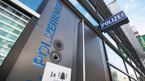 Eingang in ein Polizeirevier aus der Froschperspektive fotografiert. Die Buchstaben "Polizeirevier" und "Polizei" leuchten.