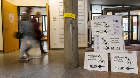 Menschen in einem Wahllokal in Frankfurt zum Bürgerentscheid über die Rennbahn.