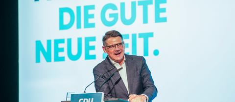 Boris Rhein steht am Rednerpult. Hinter ihm an der Wand prangt der Slogan: "Auf in die gute neue Zeit"