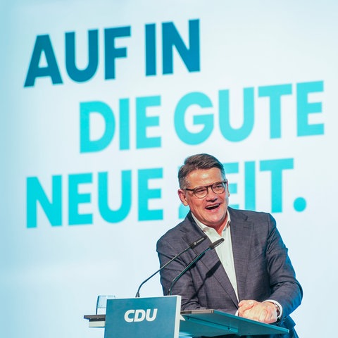 Boris Rhein steht am Rednerpult. Hinter ihm an der Wand prangt der Slogan: "Auf in die gute neue Zeit"