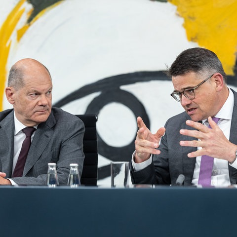 O chanceler Scholz e o primeiro-ministro Rhein sentam-se lado a lado.