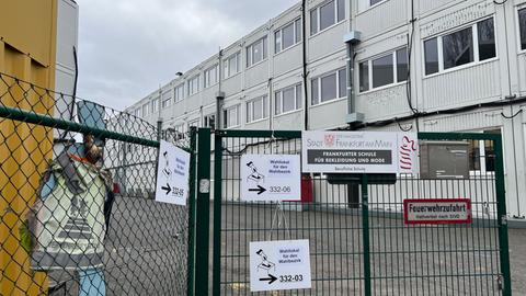 "Wahllokal" steht auf Zetteln vor der Containerschule in Sachsenhausen.