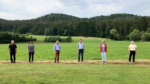 Fünf Menschen in einer Reihe auf einem Feld