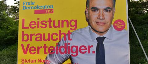 Das Bild zeigt ein Landtagswahlplakat der FDP. Darauf zu sehen ist ein Foto von Spitzenkandidat Stefan Naas sowie der Spruch "Leistung braucht Verteidiger".