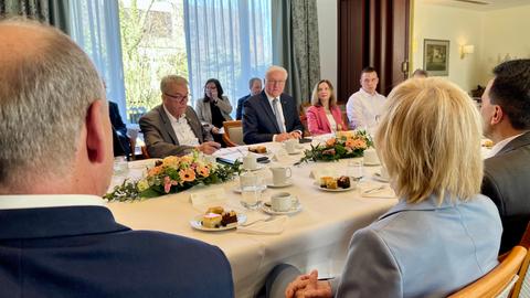 Mehrere Menschen sitzt ein Einerweißkaffeetafel