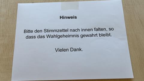 Ein Hinweisschild im Wahllokal in Weiterstadt