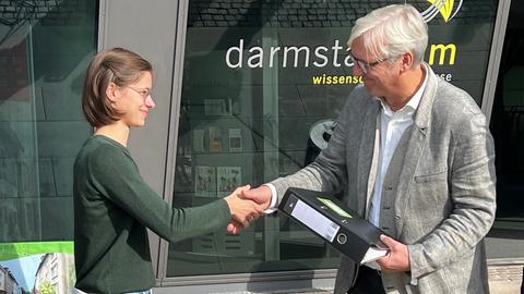 Eine Aktivistin von "heinerblocks" übergibt die Unterschriften an Darmstadts Oberbürgermeister Jochen Partsch (Grüne).