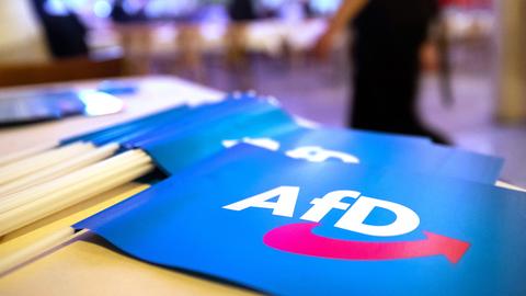 Fähnchen mit dem Logo der AfD liegen auf einem Tisch.