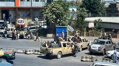 Taliban-Kämpfer patrouillieren an Bord von Polizeifahrzeugen in Kabul. 