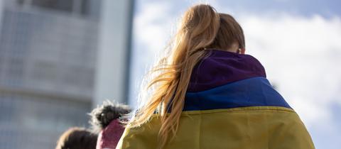 In ukrainische Flagge gehüllte Demonstrantin