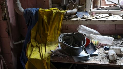 Eine ukrainische Flagge, ein Militärhelm und medizinische Dokumente liegen auf einem Tisch in einem zerstörten Teil der Metallurgieanlage Iron & Steel Works in einem von den von Russland unterstützten Separatisten kontrollierten Gebiet.