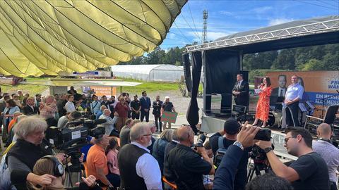 Besucher der Wahlkampfveranstaltung stehen der Bühne auf der Hubert Aiwanger steht.