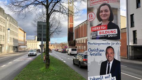 Wahlplakate von Isabel Carqueville (SPD) und Christian Geselle (SPD) hängen übereinander am Steinweg in Kassel.