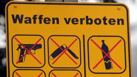 Symbolbild: Ein Schild "Waffen verboten" ist an einem Mast befestigt. 