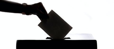 Ein Wähler wirft seinen Stimmzettel in eine Urne.