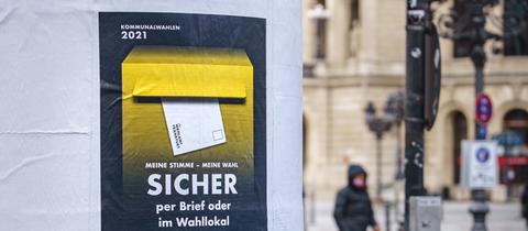 Das Bild zeigt eine Säule in Frankfurt, an der eine Aufforderung zur Wahl angebracht ist.
