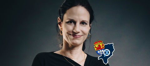 Portrait Kerstin Lau. Auf dem Bild eine kleine Grafik mit einer blau eingefärbten Fläche (Umriss der Stadt), dem Wappen der Stadt Darmstadt und einem Wahlkreuz.