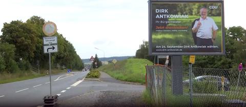 Ein großflächiges Wahlplakat hängt am Straßenrand in Neustadt (Marburg-Biedenkopf)