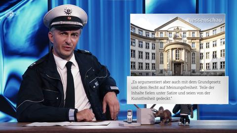 Moderator Böhmermann mit Polizei-Mütze an Moderationstisch