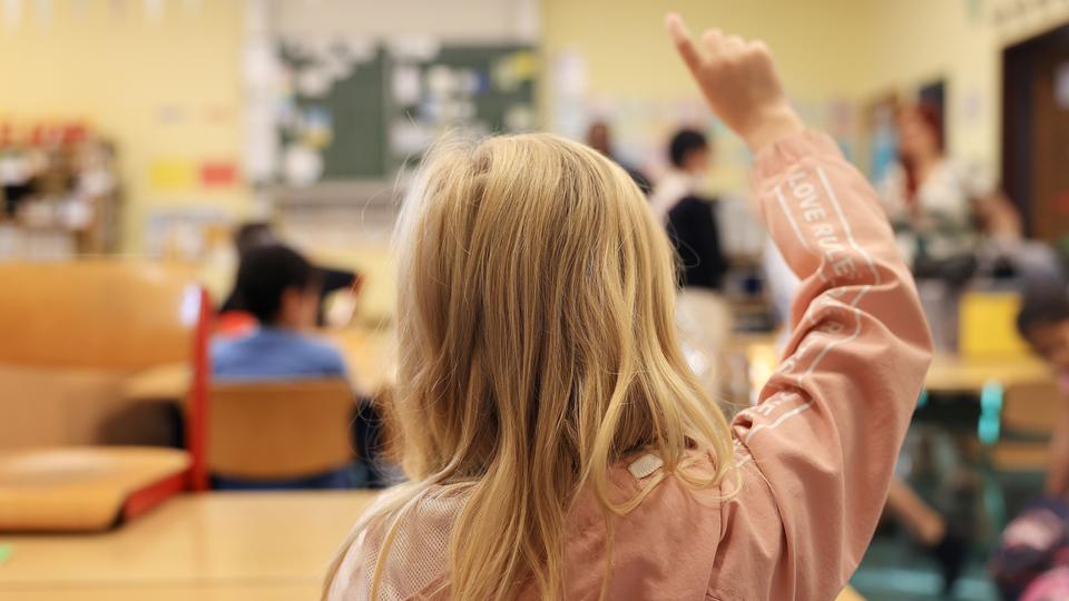 Ein Mädchen meldet sich im Unterricht